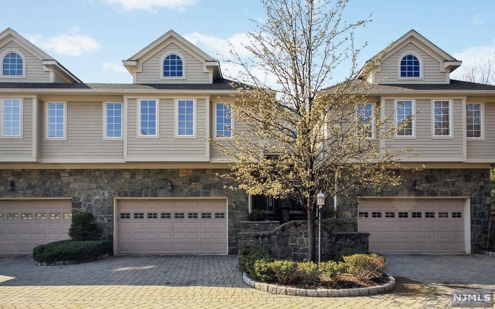 This gorgeous unit in the upscale Victoria Square Townhouse community is located on the east hill of Tenafly. The handsome exterior is stone faced with hard-plank construction, paver driveway and lush landscaping. The entry foyer leads into a spacious and airy living room with fireplace, lovely built-ins, crown moldings, hardwood floors and french doors to a private paver patio, formal dining room, large gourmet kitchen and breakfast area offering granite countertops and stainless steel appliances. The second level has a huge master suite with siting area, large walk-in closets, master bath with jacuzzi, 2 additional bedrooms plus large bathroom. The lower level has a recreation room, full bath and lots of storage.