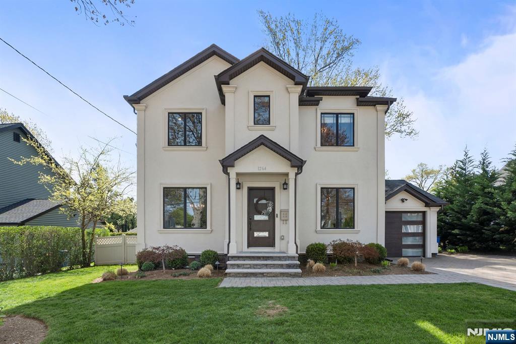 An exceptional opportunity to own a residence that seamlessly blends transitional elegance with modern sophistication. The striking stone and stucco facade, attached garage, and expansive paver stone driveway set the stage for refined living. A welcoming foyer introduces the open-concept main level with formal living and dining rooms adorned with custom millwork. The gourmet eat-in kitchen features premium stainless steel appliances, a walk-in pantry, and designer lighting over a peninsula that opens to a soaring family room with an electric fireplace and access to a private, fenced backyard with a paver patio. A full bath and a mudroom complete the main level. Upstairs, four generously sized bedrooms include a luxurious primary suite with dual walk-in closets and a spa-inspired ensuite. A stylish hall bath and laundry room add convenience. Finished lower level offers a spacious rec room and ample storage. Ideally located near NYC transit, top schools, fine shopping, and major highways.