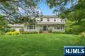 Welcome to this beautifully updated 4-bedroom, 3.5-bath colonial, on a quiet cul-de-sac block and just under an acre of land with a tranquil natural setting. The curb appeal shines with a new roof, Hardie Plank siding, and windowsâ€”delivering both style and assurance. Inside, youâ€™re greeted by a bright, airy layout with neutral tones, hardwood floors, and modern finishes. The open-concept kitchen serves as the heart of the home, with stainless steel appliances, quartz countertops, 42â€ cabinetry, and picturesque views through oversized windows. Flowing seamlessly into the family room, enjoy gatherings around the inviting wood-burning fireplace. A convenient pantry, powder room, laundry room with slop sink and built-in cabinetry complete the main floor.Upstairs, discover four spacious bedrooms, including primary suite with a walk-in closet and private full bath. The finished walk-out basement expands your options with a built-in bar, full bath, and plenty of space for a rec room, home gym, or office. Step outside on the oversized wooden deck, where you can relax and take in the wooded view with its calming streamâ€”a true retreat right at home. Two NYC commute options: train from Ramsey Station or Coach bus from Montvale Park & Ride with free-parking.