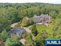 This elegant High Mountain Estate offers luxury, privacy, and tranquility minutes from NYC secluded on 6.5 acres, with manicured grounds & stunning acre of a koi fish lake, with fountains & bridge. Over 18,000 sq ft of luxurious living this Georgian Manor sits majestically overlooking the properties natural beauty, designed for maximum privacy with a double entrance & gates, featuring all year heated indoor pool with exercise jets, windowed fitness center, world-class lit tennis court, landscaped gardens, carriage house, gatehouse & 6 car heated garage with epoxy flooring. The classic architecture is notable by the custom millwork & coffered ceiling in the exquisite cherry library & throughout the estate. The Tuscan Style Kitchen opens to a two-story family ,dining area with 18' ceilings overlooking the pool and cabana. This one-of-a-kind estate is perfect for extended family, home office & separate private living quarters.