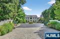 First time offered by the builder himself! Welcome to Your Private Estate set on a lovely 3/4 acre lot! Experience comfort and fun in this stunning gated residence with classic country charm, designed for luxurious living and effortless entertaining. From the moment you enter the gates, you are greeted with elegance as you approach the circular drive and enter the two story foyer. First you will notice all of the detailed trim work and custom moldings throughout. The heart of the home is a gourmet chefâ€™s kitchen, fully equipped with top of the line appliances, custom cherry cabinetry, and an expansive island open to the cozy family room. Above are 4 spacious bedrooms and 3 full baths including a grand primary suite with dressing area and modern bathroom overlooking the park like yard. The home boasts a full finished ground-level suite, complete with its own living area and separate entrance, perfect for guests, extended family, or a home office. Step outside to your own private paradise. Resort style pool surrounded by meticulously landscaped grounds. Many town wide parties have been held here on the spacious composite deck tiered to the yard with an outdoor granite kitchen and covered lounge area off the lower level. The barn has added space for gym, recreation, or a hobby shop. Wander the sidewalk in minutes you are at the town shops, restaurants, schools, library and the famous Ramsey farmer's market. NYC trains just down the road for a quick commute.