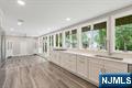 Completely Transformed Modern Masterpiece in Prime Wyckoff Location! A spectacular 5-bedroom, 3 full/2 half-bath home, offering nearly 4,000 sq ft of living space on a landscaped .65-acre lot. Thoughtfully reimagined with no detail overlooked, this stunning residence blends sophistication with everyday comfort & flexibility. Step onto the covered porch & into the grand 2-story foyer, where natural light floods through expansive windows. The open-concept layout flows into a spacious living room & elegant dining rm. The heart of the home is an incredible chef's kitchen, featuring premium appliances, custom cabinetry, & delightful breakfast room with built-ins, floor-to-ceiling windows, & access to the rear patio your private outdoor oasis. Off the breakfast rm is a mudroom/laundry room, powder room. The 24x20 great room with fireplace & oversized windows offers the perfect gathering space plus entry attached 2-car garage. A sought-after 1st-floor primary suite is tucked away in its own wing, with luxurious full bath, glass shower, skylight, & custom walk-in closet. The 2nd level overlooks the dramatic foye r& features 4 generously sized bedrooms, with walk-in closets, & 2 gorgeous full baths. The finished lower level offers additional flexible space, ideal for a rec room & extra storage. Other highlights include gleaming wood floors, recessed lighting, oversized driveway, top-tier finishes, & sun-drenched interiors. This home offers modern touches, space, serenity & LOCATION!